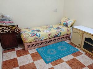 a couch sitting in a room with a checkered floor at Appartement à côté de l'aéroport in Marrakesh