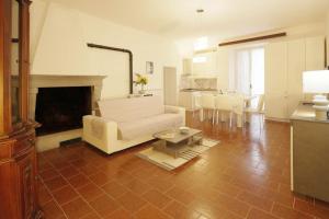 a living room with a white couch and a fireplace at La Casa nel Borgo Medievale (Lago di Trasimeno) in Passignano sul Trasimeno