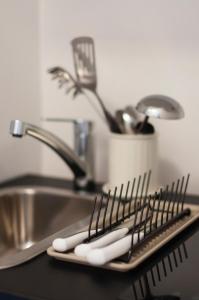 a kitchen counter with a sink and a tray with spatulas at Work & Stay Zagreb in Zagreb