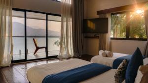 a hotel room with two beds and a large window at Villa Karma Pokhara in Pokhara