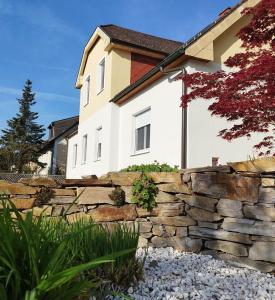 a stone retaining wall in front of a house at Ferienzimmer Reinisch in Tattendorf in Tattendorf