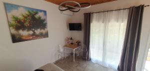 a room with a window with a table and a painting at Litochoro Appartment in Estate A2 in Litochoro