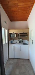 a kitchen with white cabinets and a wooden ceiling at Litochoro Appartment in Estate A2 in Litochoro