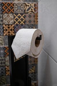 un rouleau de papier toilette suspendu sur un mur dans l'établissement Kníže Ferdinand Apartments, à Mikulov