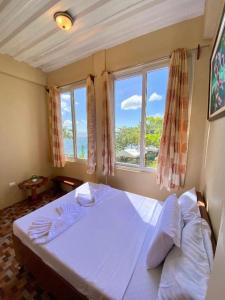a bedroom with a white bed and a window at Oceanfront Beach Resort in Siquijor