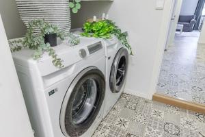 uma máquina de lavar roupa numa lavandaria com vasos de plantas em 7 Soverom i hjertet av Bergen em Bergen