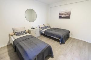 a bedroom with two beds and a mirror at 7 Soverom i hjertet av Bergen in Bergen