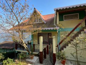 een huis met een hek ervoor bij Nimantrana Homestay in Darjeeling