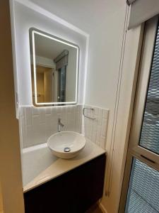 a bathroom with a white sink and a mirror at UaJemet - Modern 3 Bedroom apartment in Guatemala