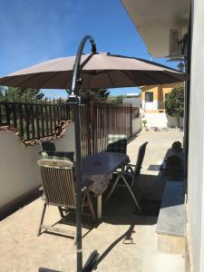 un tavolo e delle sedie sotto un ombrellone in un patio di villa mediterranea a Realmonte Altre 9 foto