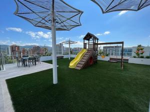 a playground on the roof of a house with an umbrella at UaJemet - Modern 3 Bedroom apartment in Guatemala