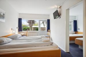 1 dormitorio con cama y ventana en BB-Hotel Frederikshavn Turisthotellet, en Frederikshavn