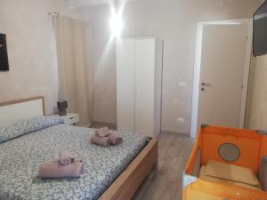 una camera da letto con un letto con due asciugamani rosa di Casa Opuntia Rosolini a Rosolini