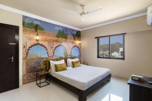 1 dormitorio con 1 cama con una pintura en la pared en Lazy Daze by UCH, en Udaipur