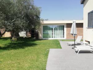 un patio con due sedie da giardino e un ombrellone di Casa Opuntia Rosolini a Rosolini