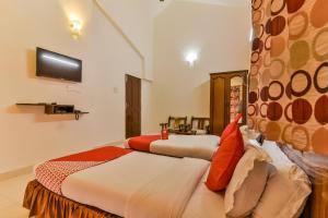 a hotel room with two beds and a tv at Triple Beach Guest House in Benaulim