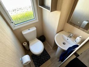 małą łazienkę z toaletą i umywalką w obiekcie Charming Chamber with spacious relaxing area w mieście Pagham