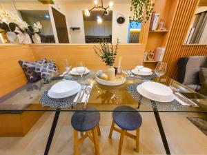 een glazen tafel met stoelen en borden erop bij The Luxury Lounge in Bacolod