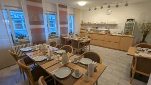 una sala da pranzo con tavoli e sedie e una cucina di Gästehaus Ziegler a Stoccarda