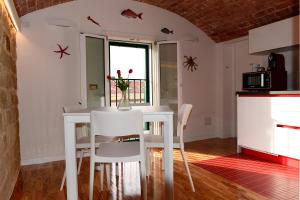 a kitchen with a white table and white chairs at Cùninarum Domus in Alghero