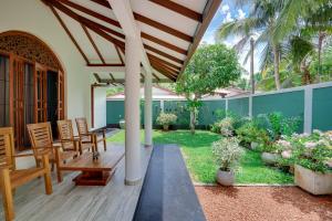 a patio with a table and chairs and a garden at Villa Sunbreeze in Beruwala