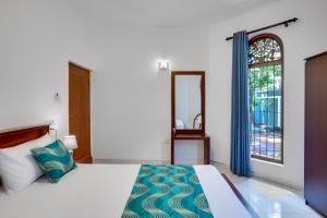 a bedroom with a large bed and a window at Villa Sunbreeze in Beruwala