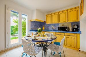 Una cocina con una mesa y sillas en una cocina. en Villa Gnoki, en Cannes