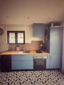 - une cuisine avec un évier et un comptoir dans l'établissement La petite maison bleue d'héricy, à Héricy