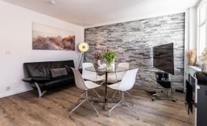 a dining room with a glass table and white chairs at Villa Helga- Fewo Nachtstern mit Terrasse, Bio-Kamin und 2 Schlafzimmer in Zinnowitz +10 photos
