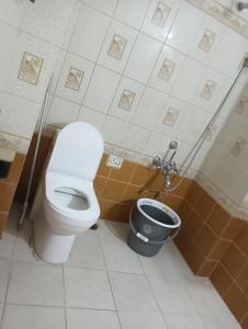 a bathroom with a toilet and a bucket at Bonjour Travellers Hostel in Hyderabad