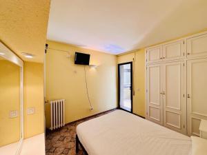 1 dormitorio con 1 cama y TV en la pared en Apartament mar i vent, en Platja d'Aro