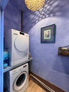 a laundry room with a washing machine and a purple wall at Maison Georges in Tourcoing