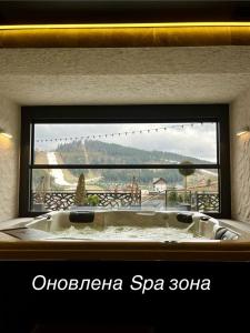 a bath tub in front of a window with a view at Chalet Fomich in Bukovel