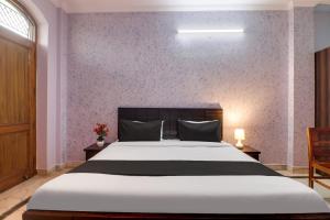 1 dormitorio con cama grande y pared morada en Super OYO Dream Homes en Nueva Delhi