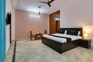 1 dormitorio con 1 cama grande y 1 mesa en Super OYO Dream Homes en Nueva Delhi