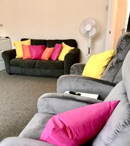 a living room with two couches with colorful pillows at Coastal Apartment in Southend-on-Sea