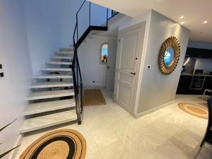 a staircase in a home with a round mirror at Villa face mer in Royan