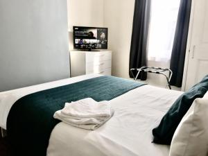 a bedroom with a white bed with a tv on it at Coastal Apartment in Southend-on-Sea