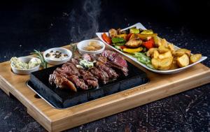 a cutting board with two plates of meat and other foods at Rheinhotel Lilie in Boppard