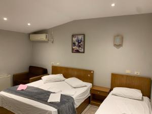 Zimmer mit 2 Betten und einem Stuhl in der Unterkunft Hotel Bicaj in Shkodra