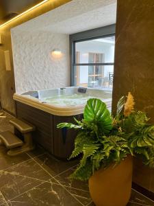 uma casa de banho com uma banheira com uma janela e plantas em Chalet Fomich em Bukovel