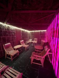 a room with chairs and tables and pink lights at Chalet Fomich in Bukovel