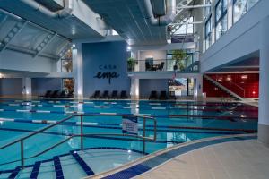 a swimming pool with blue water in a building at Casa EMA Pensiune & SPA in Bistriţa