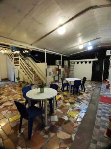 Habitación con 2 mesas, sillas y escaleras en Big Brother Condotel, en Puerto Princesa City