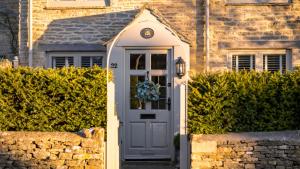 a door to a house with a wreath on it at Gable Cottage in Meysey Hampton