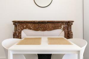 una mesa blanca con un espejo en una pared blanca en 4 - Centre historique - patio - clim en Perpiñán