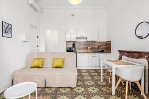 een woonkamer met een bank en een keuken bij 4 - Centre historique - patio - clim in Perpignan