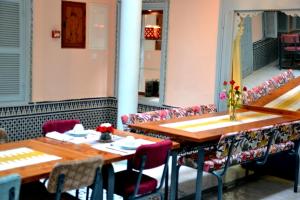 - une salle à manger avec deux tables et un canapé dans l'établissement Riad Louane, à Rabat