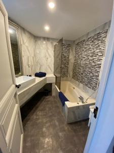 a bathroom with a tub and a sink and a bath tub at Villa face mer in Royan