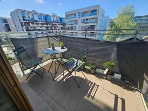 d'une terrasse avec une table et des chaises sur un balcon. dans l'établissement FIRST -- Green Żoliborz Apartment 4, à Varsovie